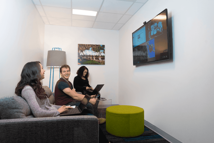 3 Workers using video conference in a huddle room