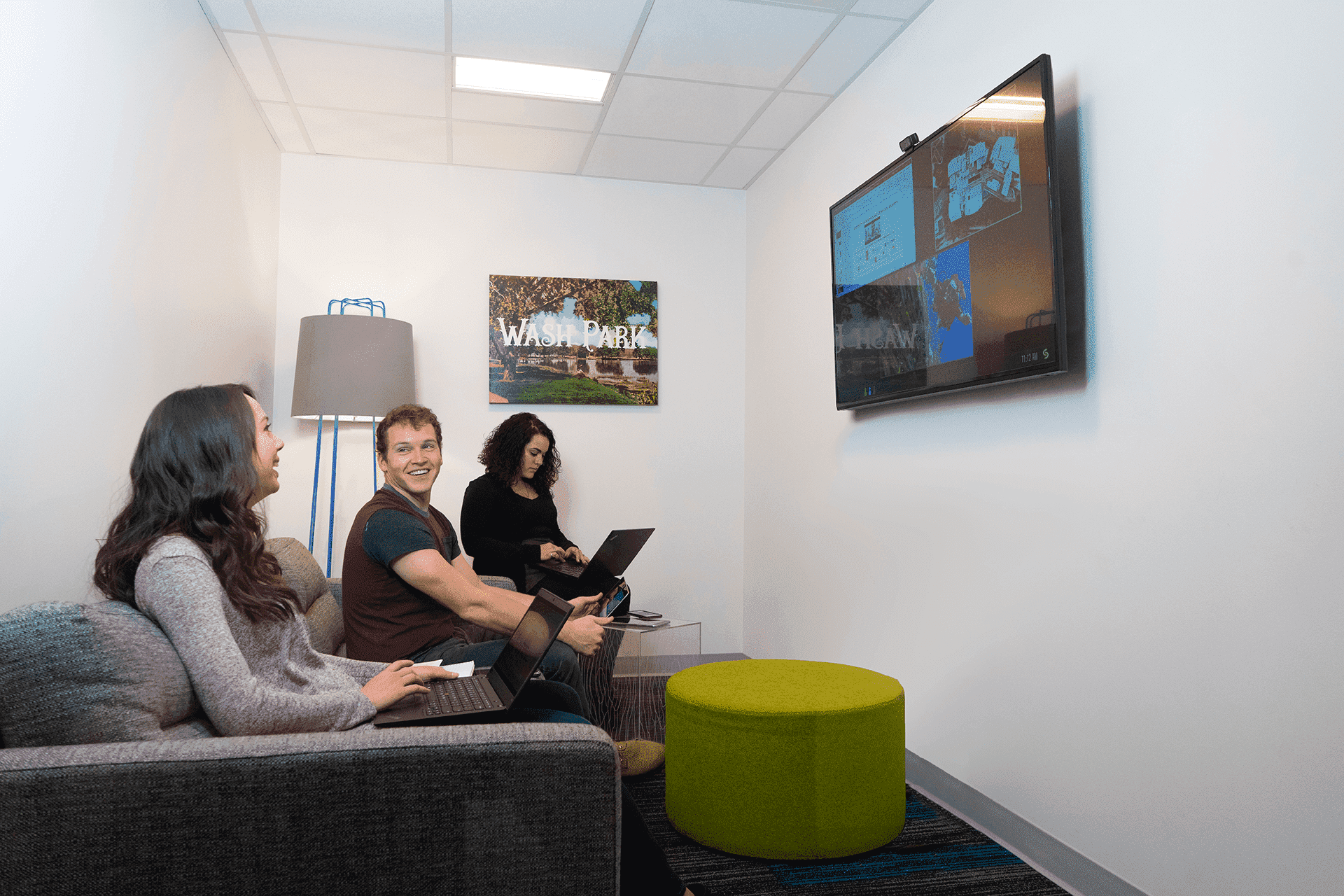 3 Workers using video conference in a huddle room
